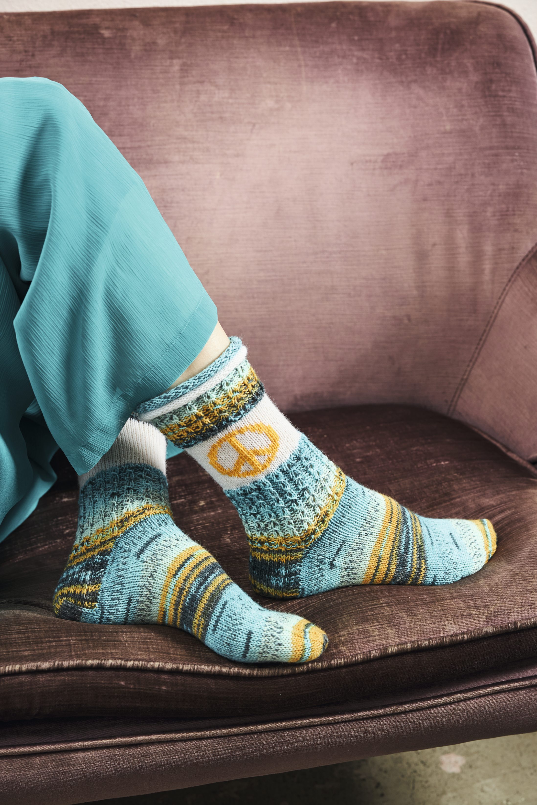 Handgemachte Socken in Blau-Gelb mit Peace-Zeichen, komplexen Mustern und modischem Strick-Look.