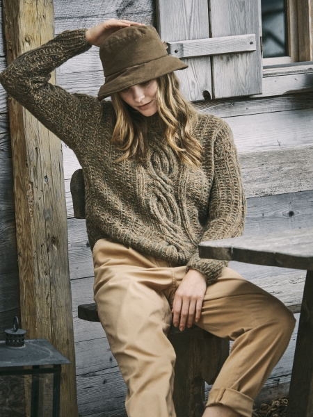 Brauner Strickpullover mit Zopfmuster und beigen Chinos; modischer, handgemachter Look mit Filzhut.