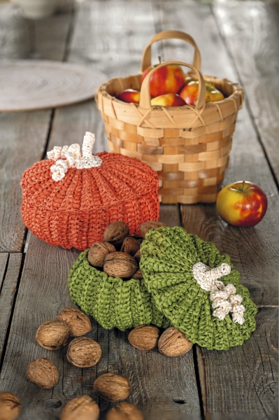 Handarbeit: Orange und grüne Kürbisse, gestrickt, strukturiert, detailreich, rustikal, DIY-Charme.