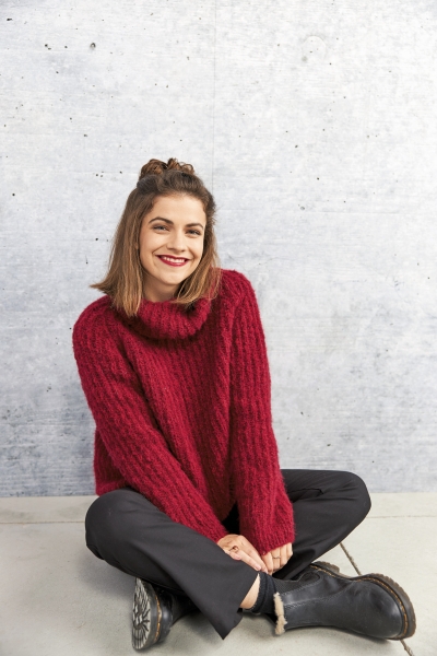 Roter, gerippter Rollkragenpullover, modisch oversized. Kombiniert mit schwarzen, eleganten Hosen.