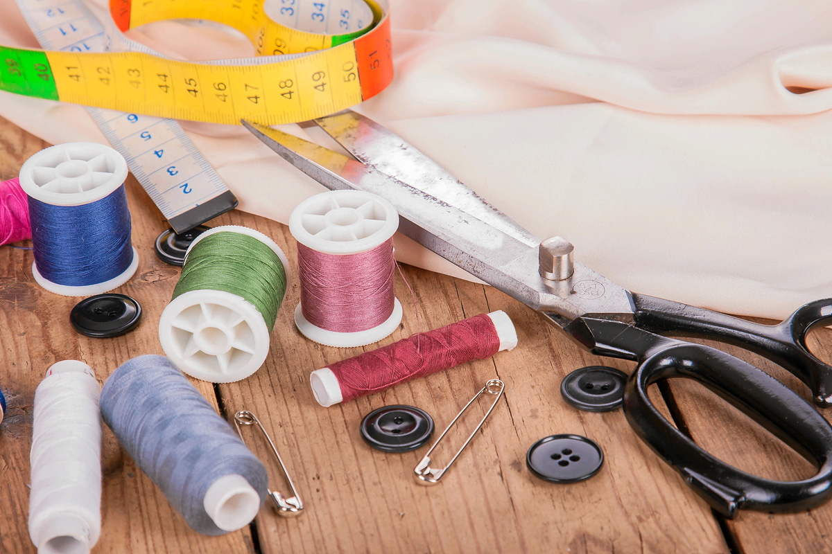 Farbenfrohe Fäden, Schere, Maßband - perfekt für modische, handgemachte Projekte.