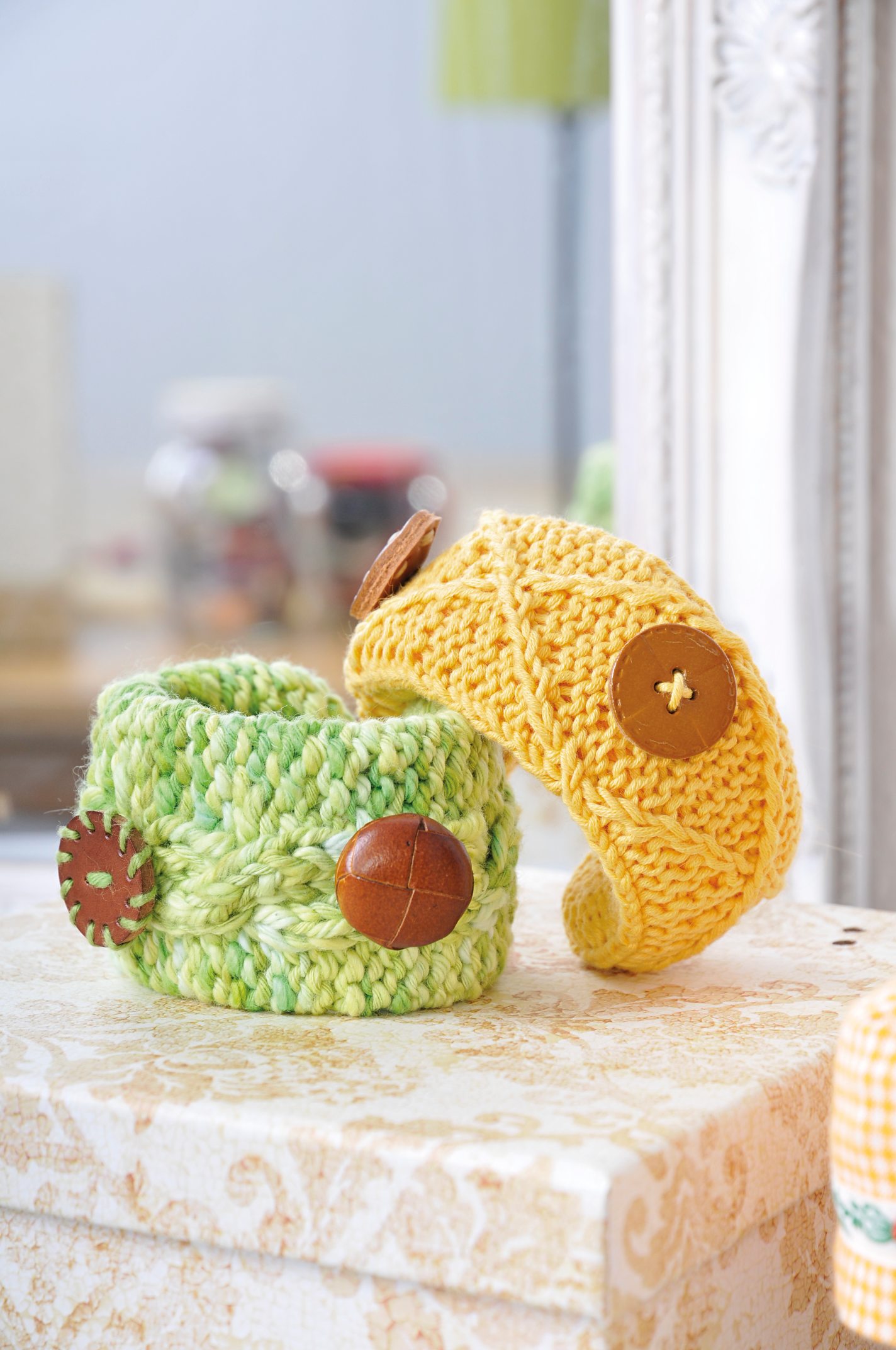 Handgearbeitet, gelb und grün gestrickte Armbänder mit großen Holzknöpfen. Modisch, einzigartig, DIY.