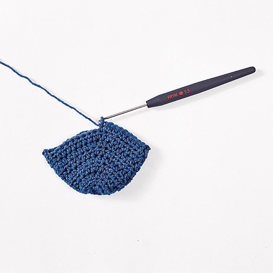 Handgemachtes, blaues Häkelstück; grobmaschiges Muster, DIY-Stil, mit Häkelnadel in Arbeit
