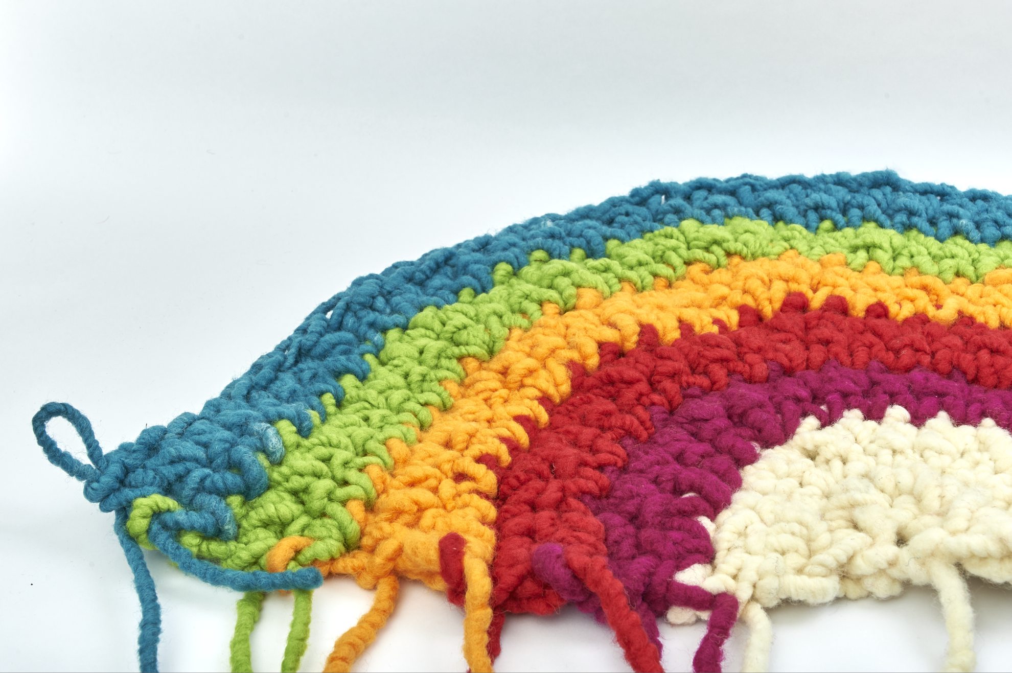 Handgearbeitetes, farbenfrohes Häkelmuster in Regenbogenfarben: Modisch, DIY, Detailreich.