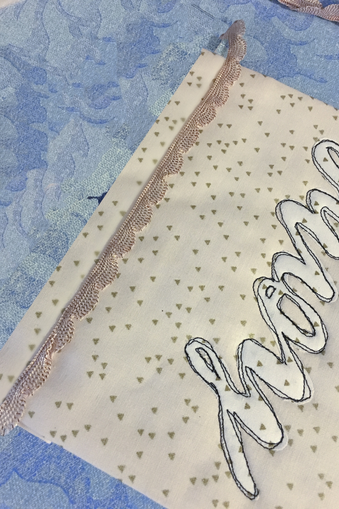 Handgemachte Textur mit blauen Wellen, cremefarbenem Stoff, goldenen Dreiecken und Details. DIY-Stil.