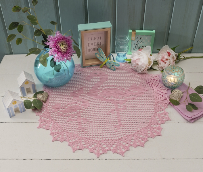 Selbstgemachte rosa Häkeldecke mit filigranem Muster, elegant und dekorativ, akzentuiert modernes Interieur.