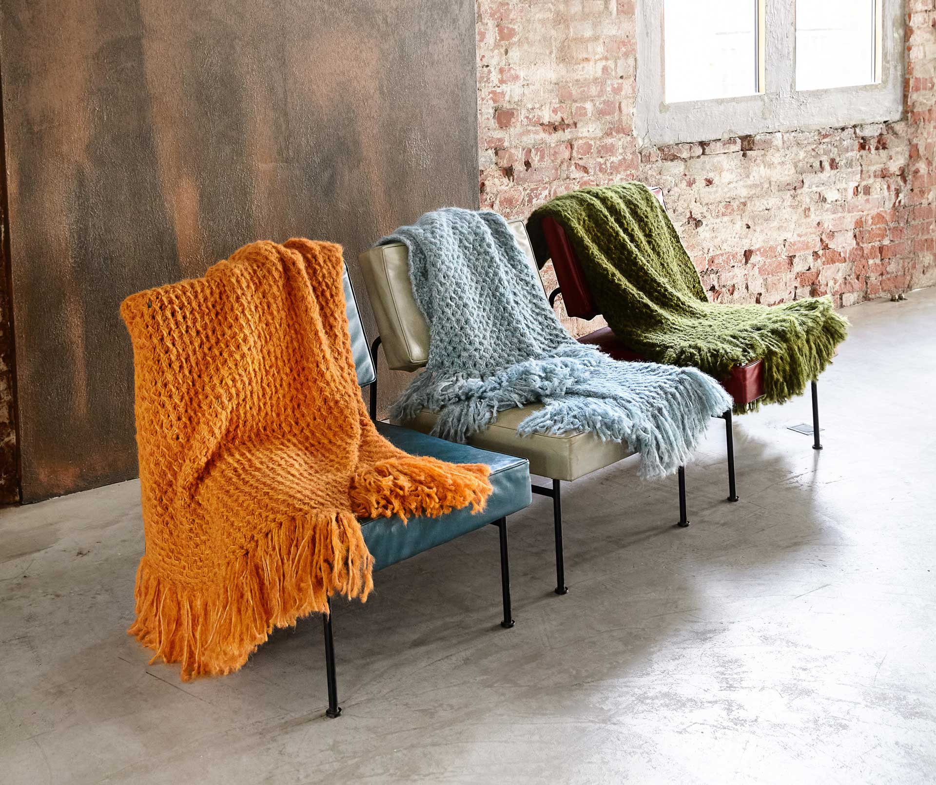 Bunte, handgemachte Strickplaids in Orange, Blau, Grün; dick gestrickt mit Fransen; gemütliches DIY-Design.