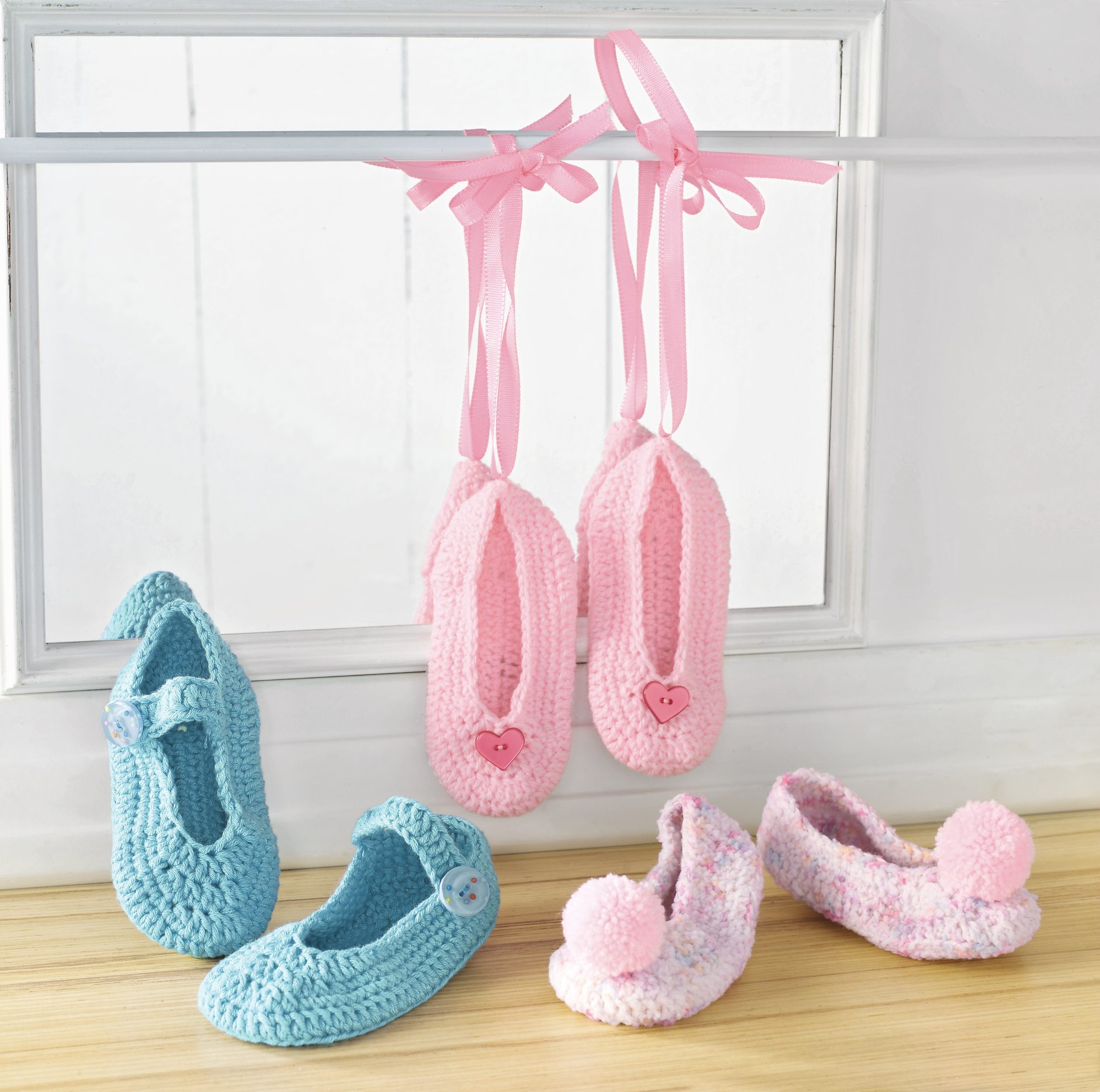 Häkelschuhe in Rosa und Blau, mit Herz- und Knopfdetails, pastellig, handgemacht, liebevolle Details.