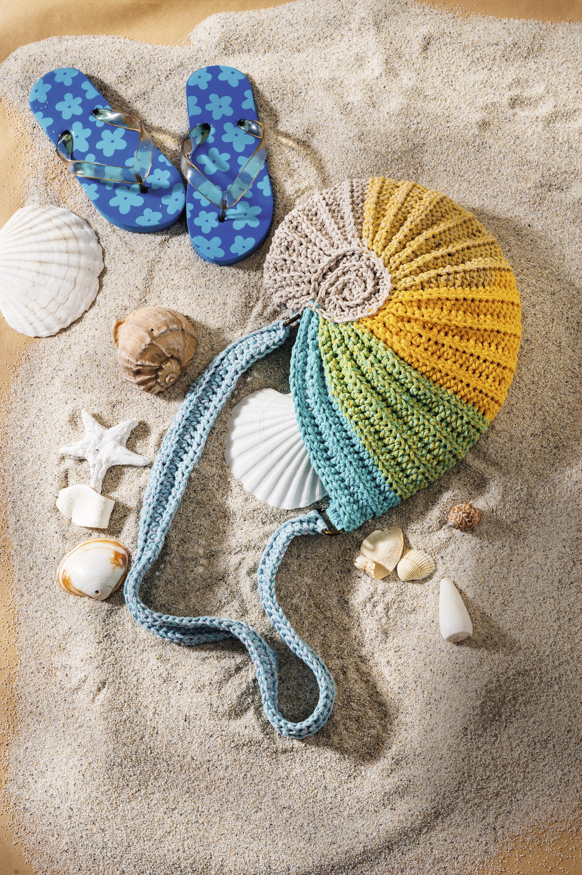 Handgemachte, bunte Tasche im Muscheldesign; Flip-Flops mit blumigen Mustern, blau. Modisch und kreativ.