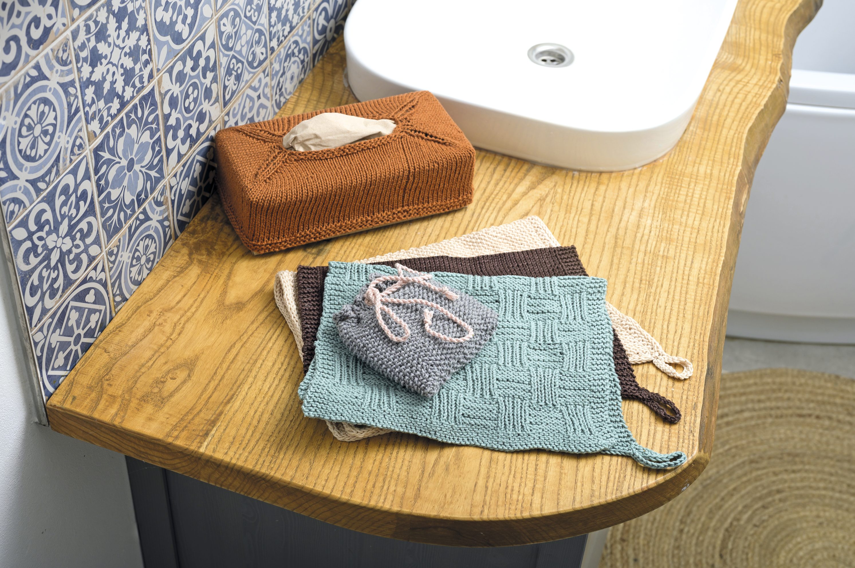 Modische, handgemachte Strickstücke in Erdtönen und Blau mit Körbchenmuster und DIY-Charme.
