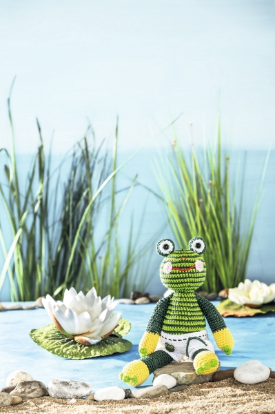 Grün gestreifter, handgemachter Frosch mit markanten Augen und kurzen Armen. Modisches DIY-Spielzeug.