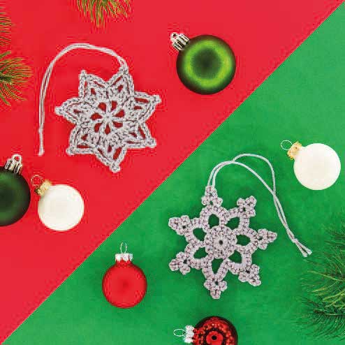 Handgemachte, gehäkelte Schneeflocken in filigranen Mustern, modisch, festlich, mit bunten Weihnachtskugeln.