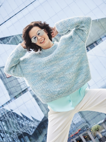 Modischer Pullover in Hellblau mit Waffelmuster, lockerem Schnitt. Kombiniert mit weißer Hose. Winterliche Eleganz.