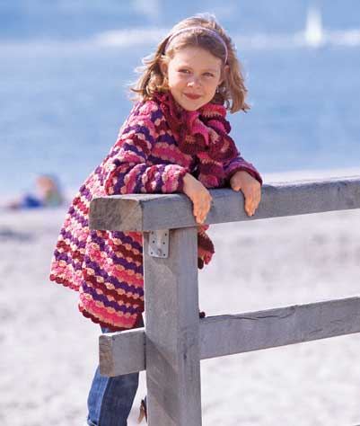 Modischer, handgemachter Strickmantel, bunt gestreift in Rosa- und Rottönen, bequemer Schnitt. Ideal für Kinder.