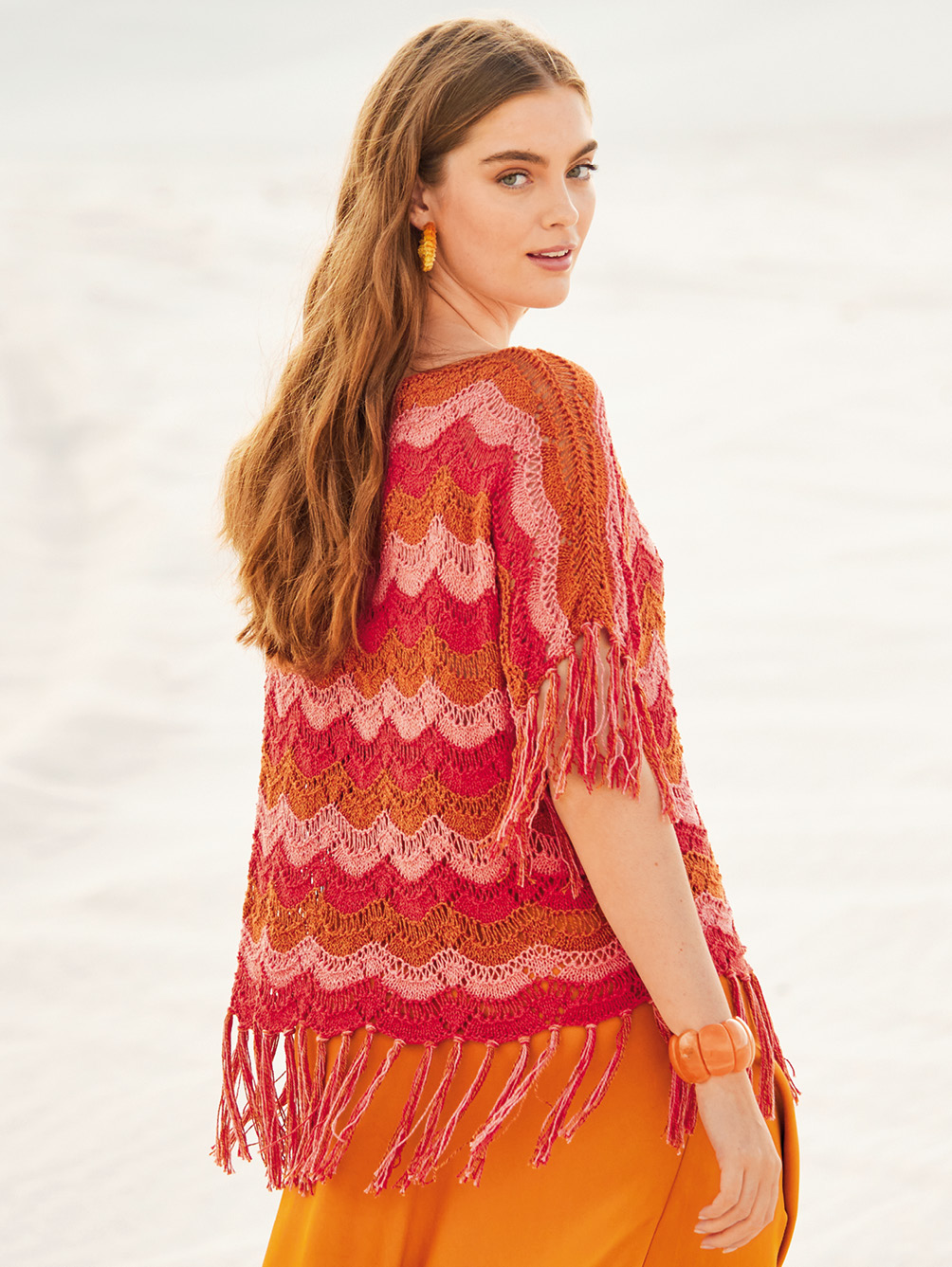 Modellansicht Bild 1: Pullover in Rot, Rosa und Rotbraun im Wellenmuster mit Fransen