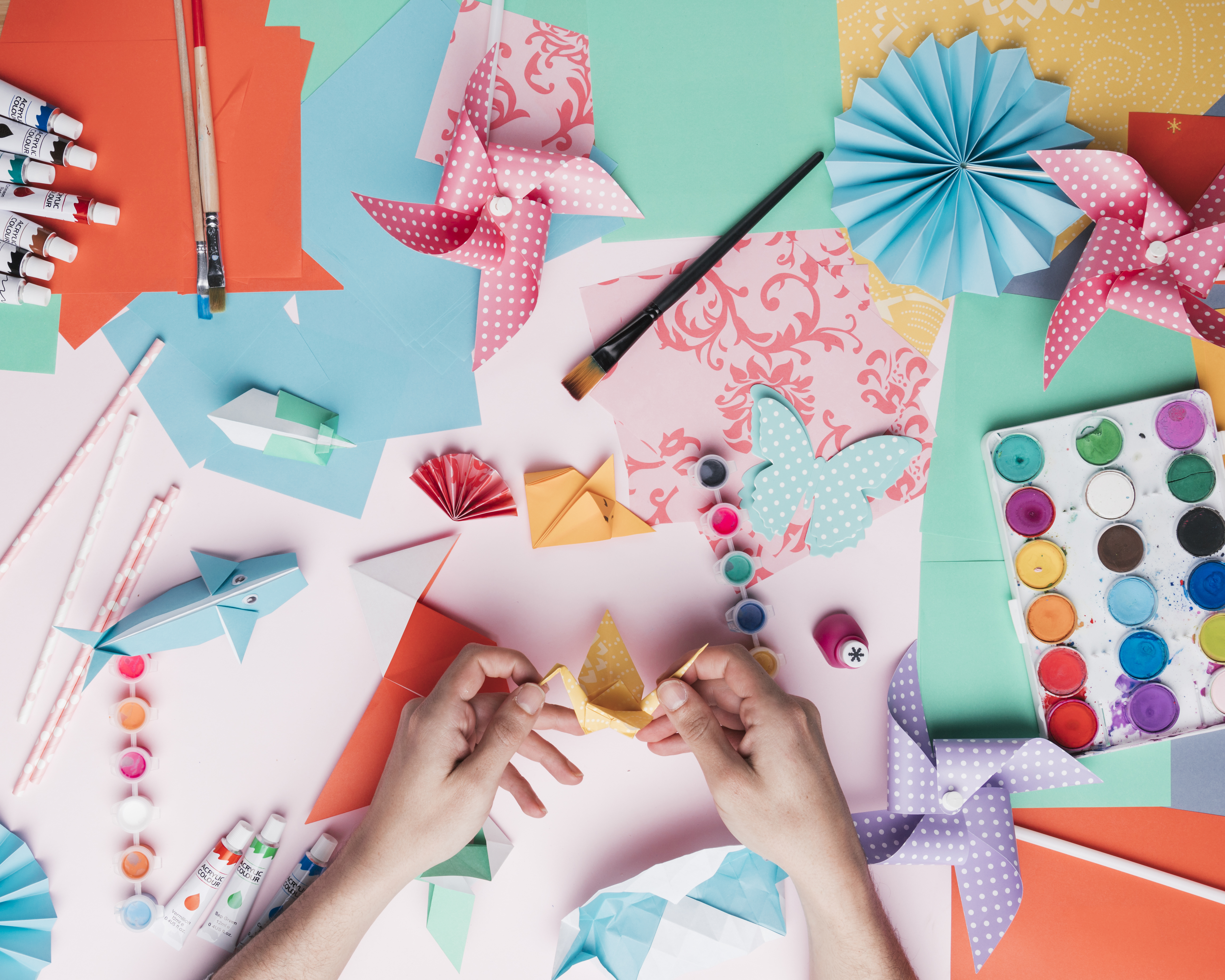 Farbenfrohe und gemusterte DIY-Origami-Kunst mit Pastelltönen. Kreative Handarbeit mit Origami und Aquarellfarben.