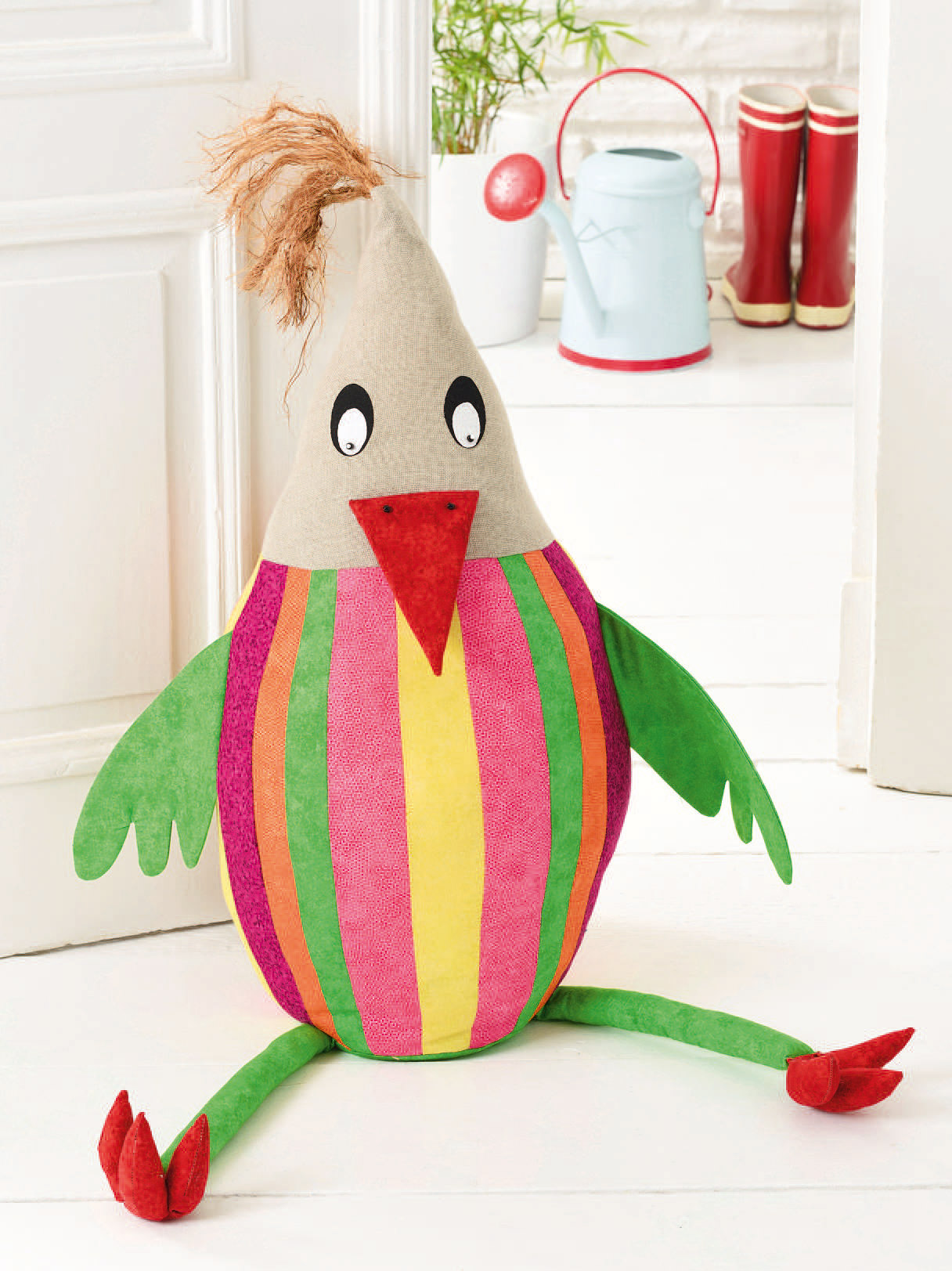 Handgemachter Vogel, bunte Streifen, grüne Flügel, rote Details. DIY-Stil, ausgefallen und kreativ.