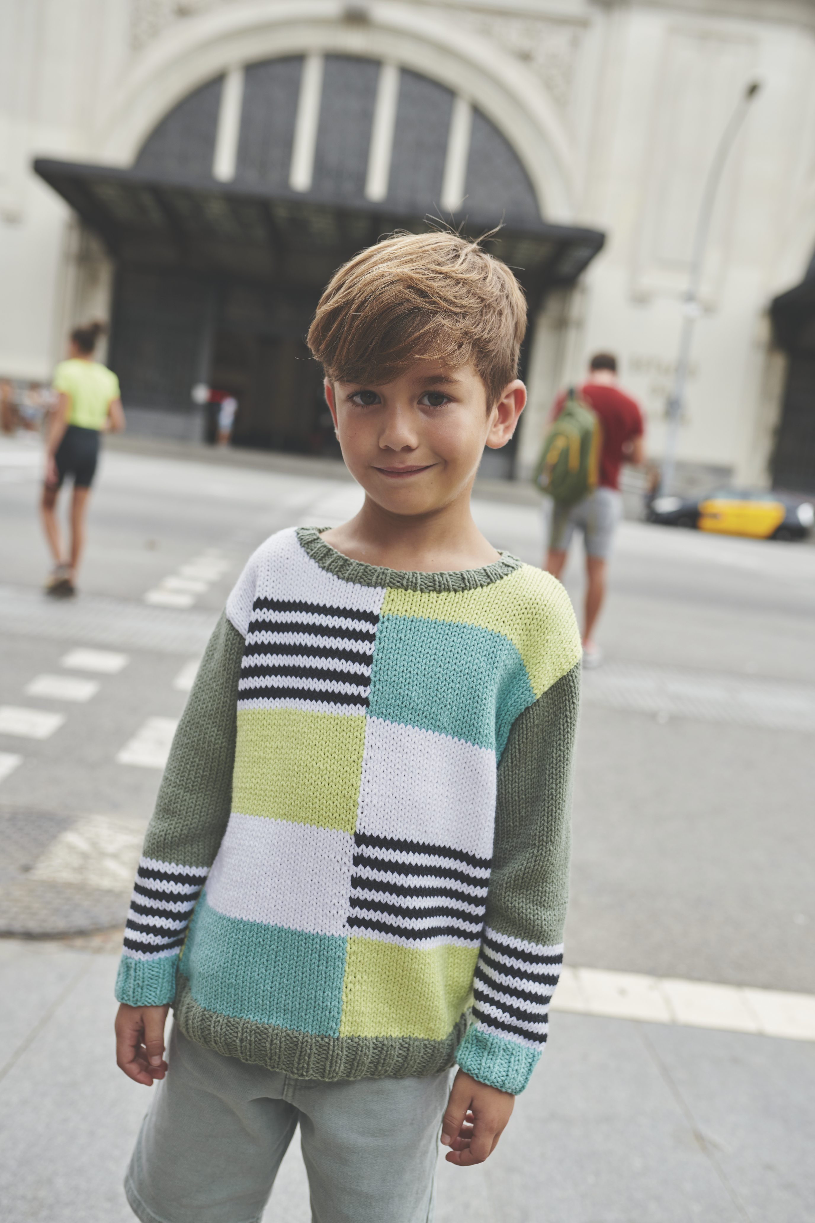 Modischer Pullover mit buntem Patchwork-Muster, Streifen und Farbblöcken. Handarbeit, DIY-Charme.