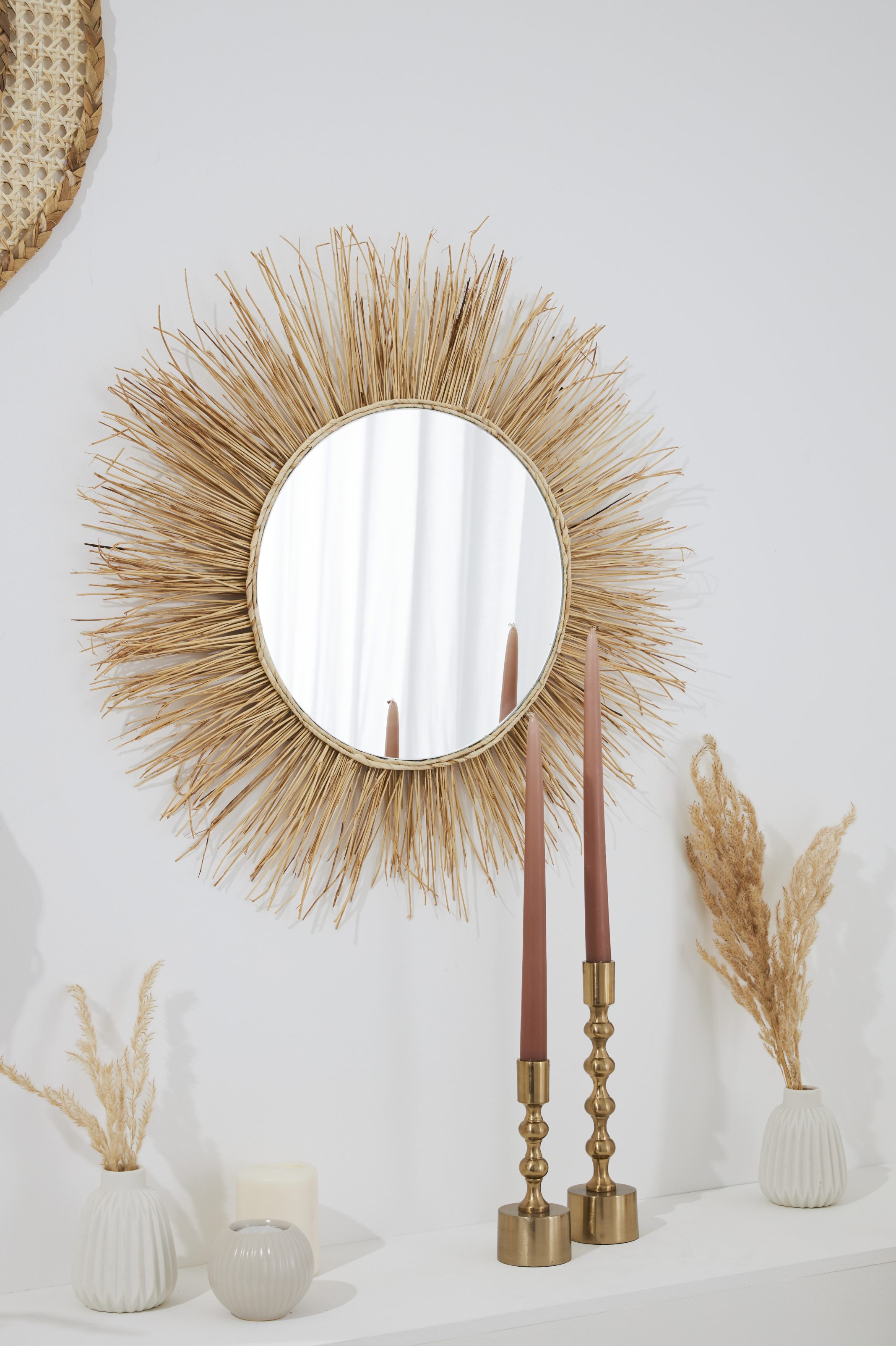 Runder Spiegel mit rand aus naturfasern, goldene Kerzenhalter, zierliche Vasen, harmonisches DIY-Design.