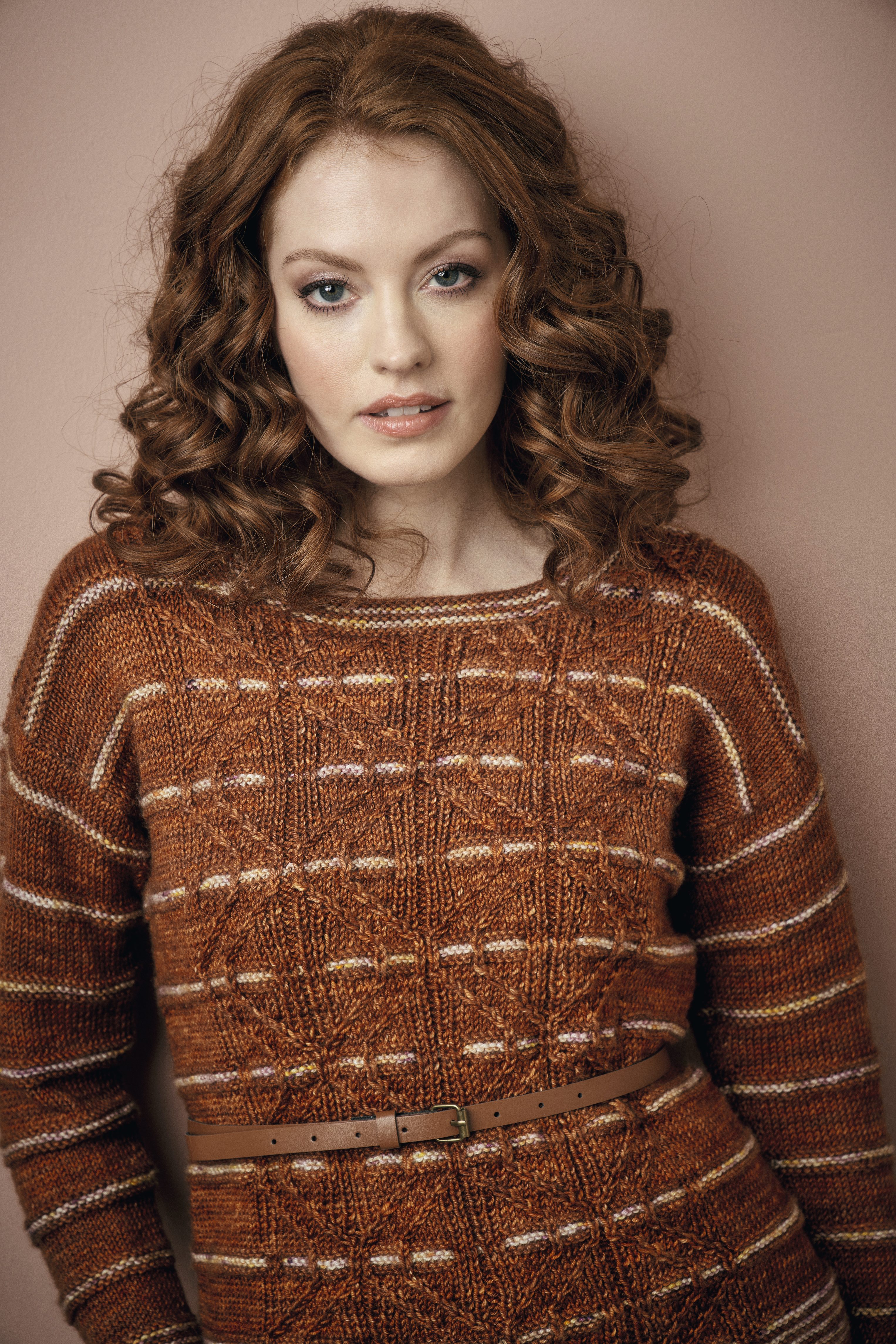 Kastanienbrauner Strickpullover, geometrisches Muster, modisch, selbstgemacht, schmaler Gürtel, warme Erdtöne.
