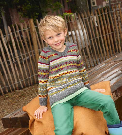 Bunter, gemusterter Strickpullover im V-Schnitt, kombiniert mit grüner Hose. Modisch, handgemacht.