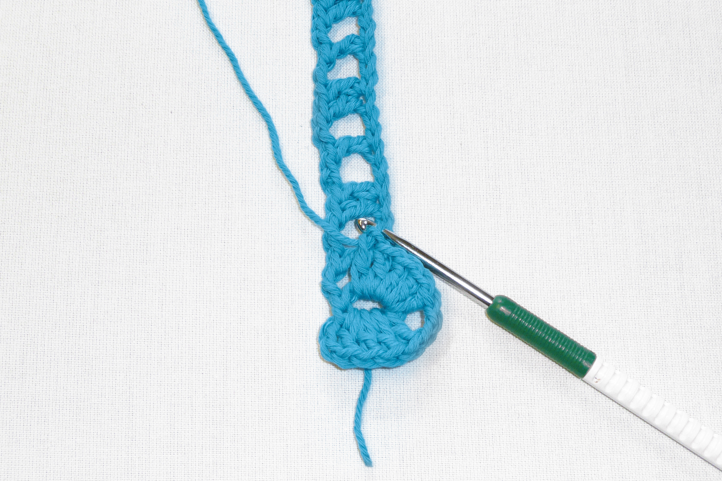 Handgemachter Häkelstreifen in leuchtendem Blau, gemustert, DIY-Charakter, filigran gearbeitet.