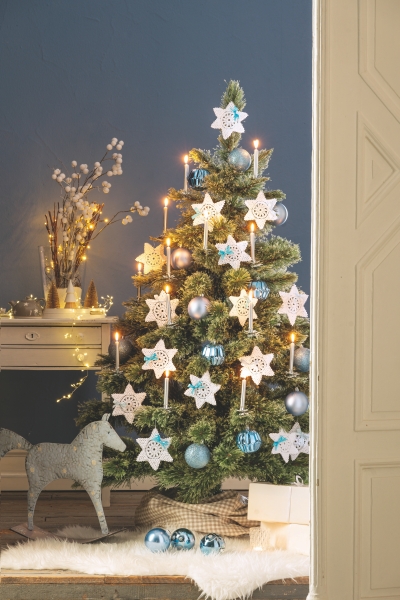 Blauer, weißer Baum mit DIY-Sternen, glänzenden Ornamenten, stimmungsvoller, handgefertigter Festlichkeit.