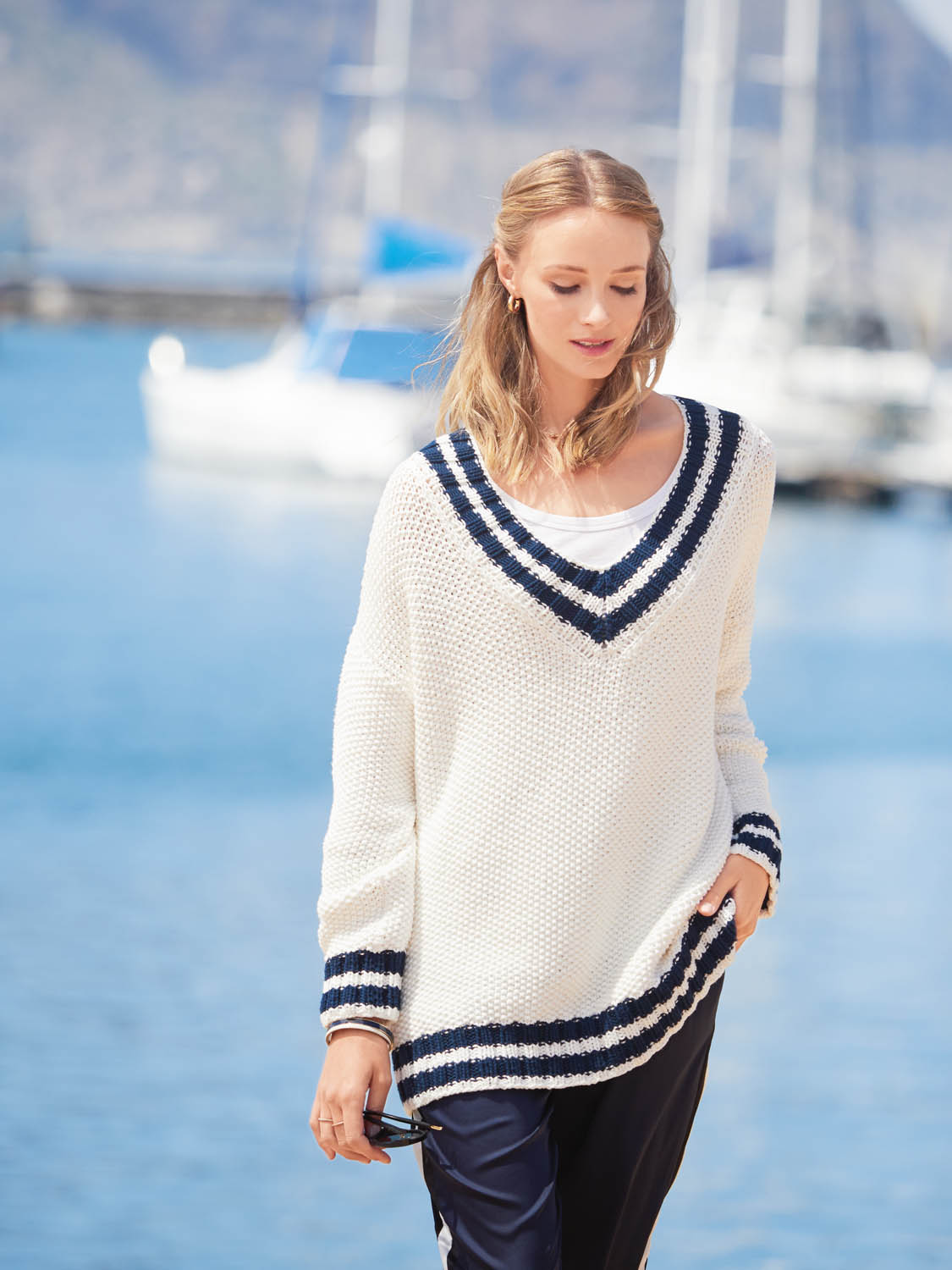 Weißer, grob gestrickter Pullover mit dunkelblauen Streifen und V-Ausschnitt. Lässiger Schnitt, modisch elegant.