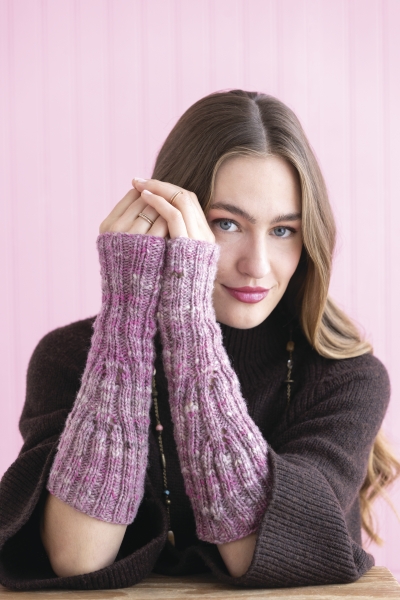 Lila melierte Handstulpen, selbstgemacht, mit Rippenmuster. Dunkler Pulli kontrastiert elegant.