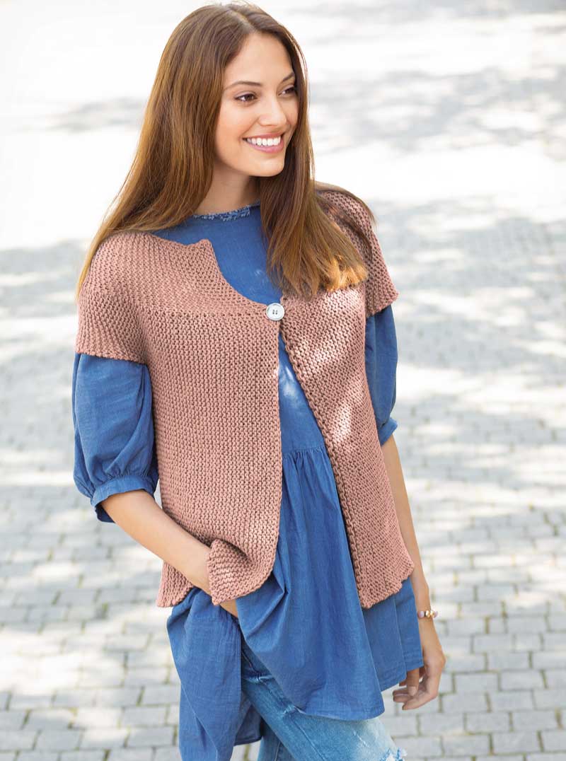 Modische, handgestrickte Weste in Rosa über blauer, lässiger Tunika; DIY-Stil, gemütlich und zeitlos.