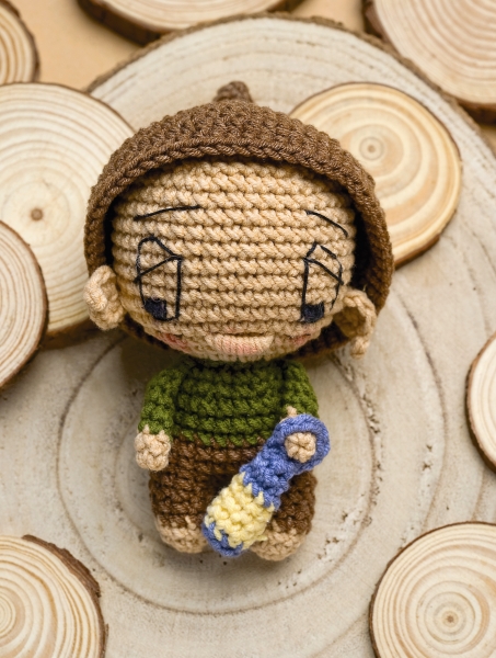 Handgemacht: Puppe mit braunem Hut, grünem Oberteil, brauner Hose, blau-gelber Flasche. DIY, niedlich, kreativ.