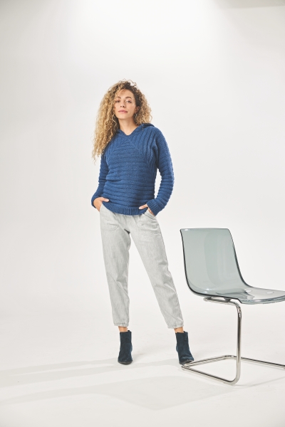 Blauer, handgemachter Pullover, gerippt; weiße, lockere Hose. Modisch, schlicht, komfortabel.