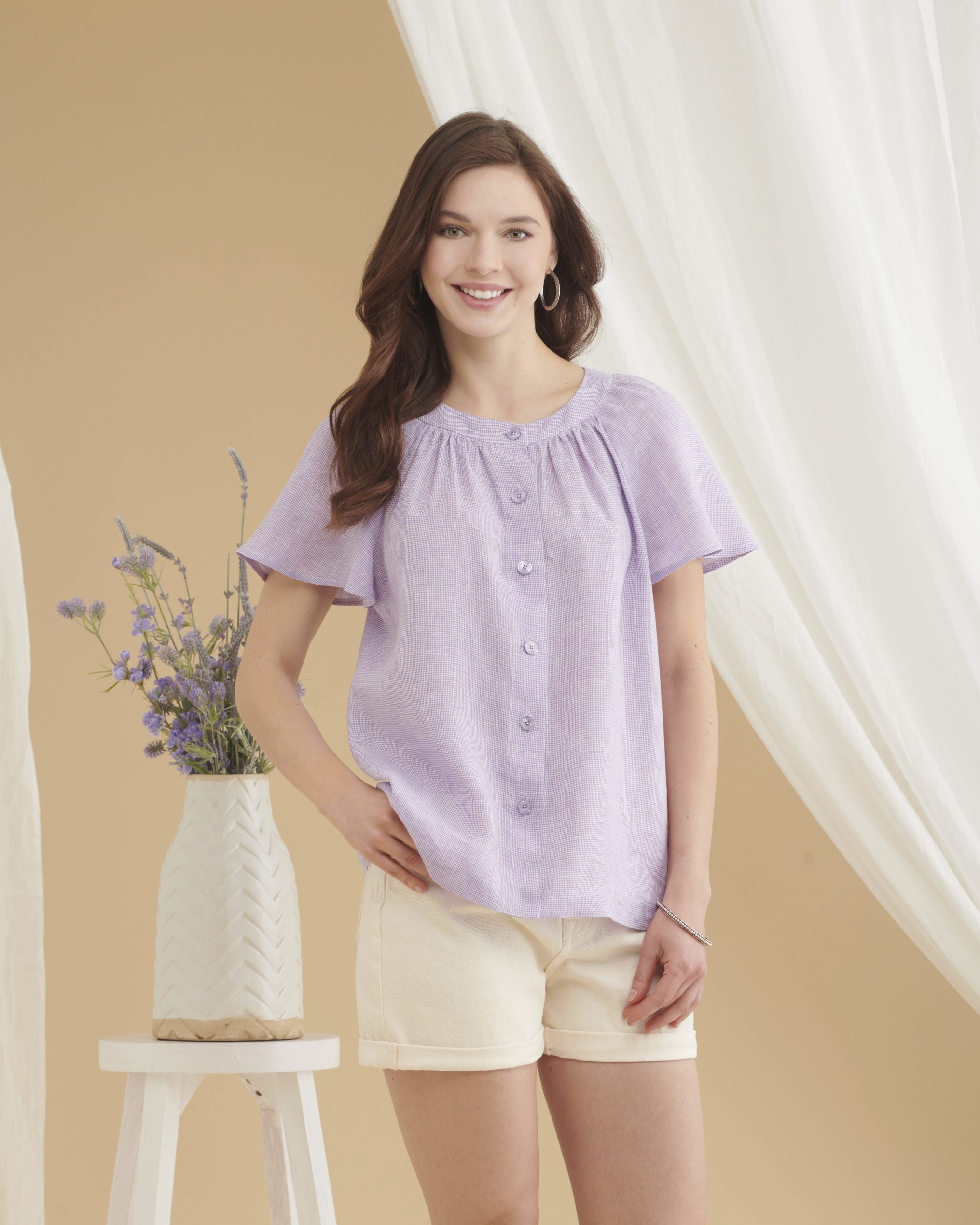 Lila Bluse mit Knopfleiste, lockerer Schnitt, kurze Ärmel, modisch, pastellfarben, cremige Shorts, Sommerlook.