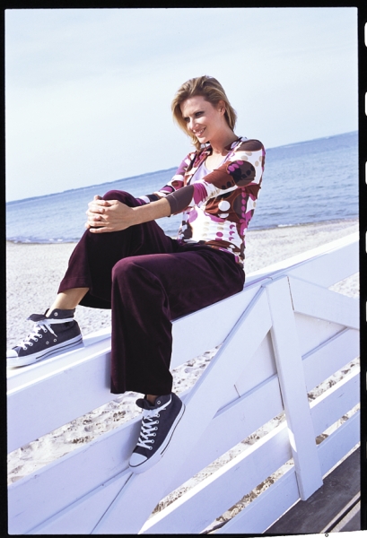 Modisches Shirt mit geometrischem Muster, weite Hose in Dunkelviolett, sportliche Sneakers. Lässig-modern.