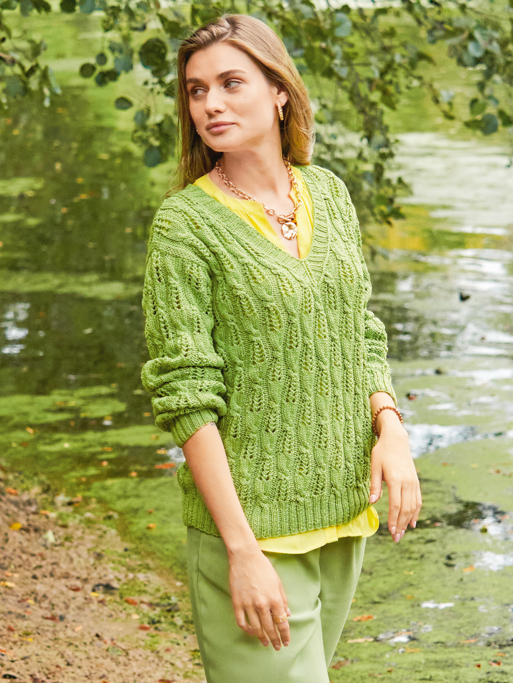 Modellansicht Bild 1: Pullover mit V-Ausschnitt und Zopf-Lochmuster in Grün