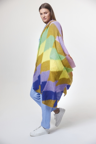 Modischer Poncho in geometrischem Muster, pastelligen Farben, handgemacht. Lässiger Schnitt, DIY-Stil.