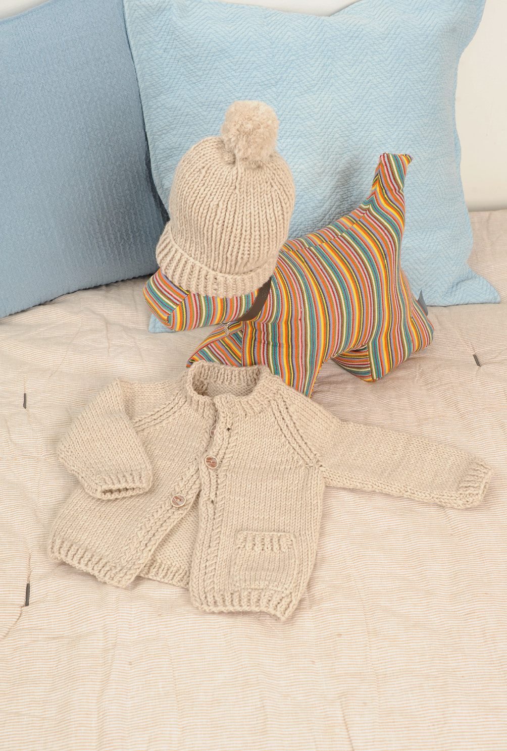 Beigefarbene Jacke  und rosafarbener Pulli mit Mütze