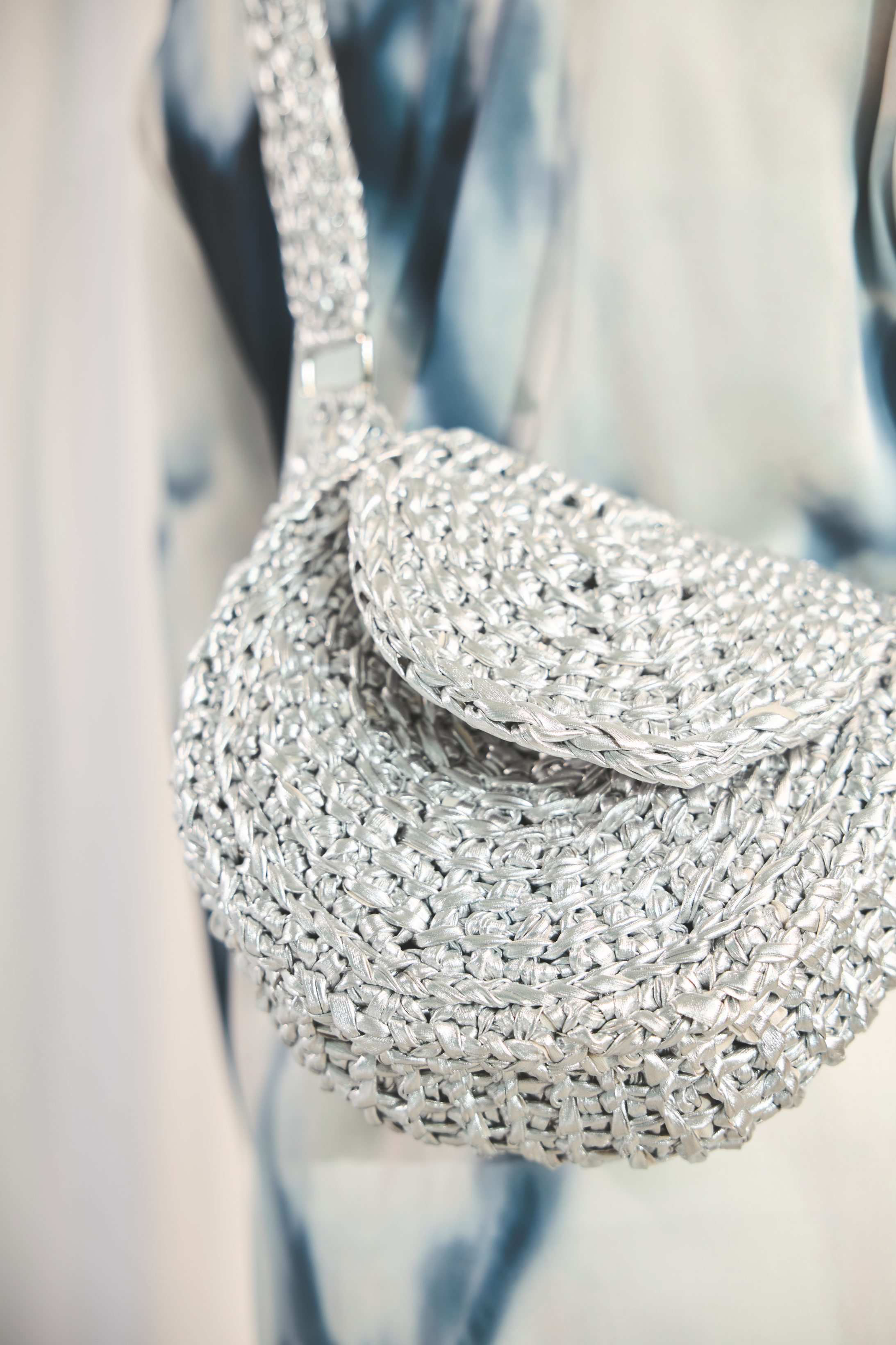 Handgemachte Tasche in silbernem, gehäkeltem Design. Modische Struktur, glänzend und einzigartig.