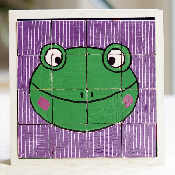 Puzzle mit grünem Frosch auf lila Hintergrund, handgemalt, kreativ, einzigartig, lebhafte Farben.