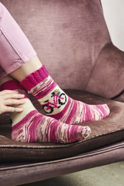 Handgestrickte Socken in Rosa, Weiß mit Fahrradmotiv, streifenartig gemustert, selbstgemacht.