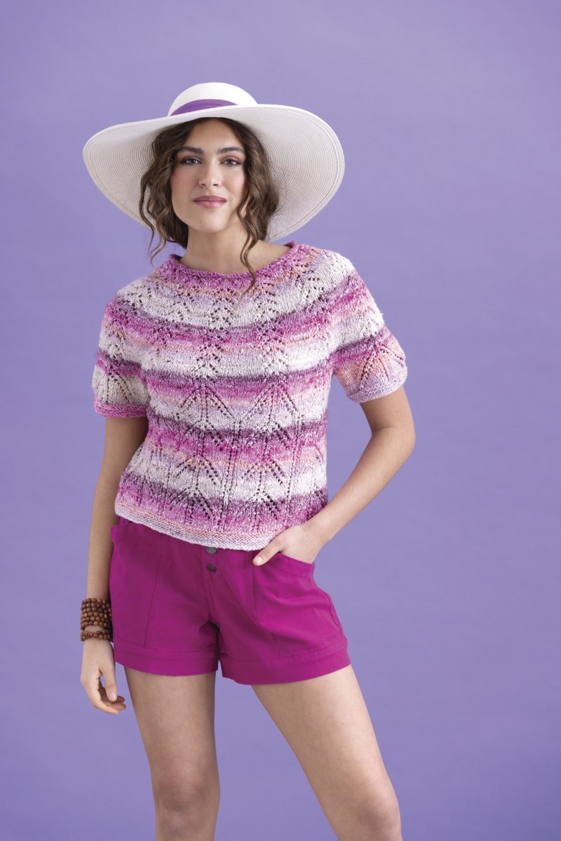 Gemusterter, handgemachter Pullover in Rosa-Weiß-Tönen, kombiniert mit pinken Shorts. Modisch, DIY.