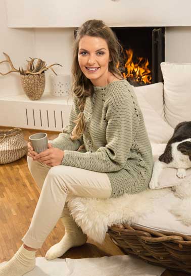 Selbstgemachter, grüner Strickpullover mit lockerer Passform, kombiniert mit hellen, bequemen Hosen.